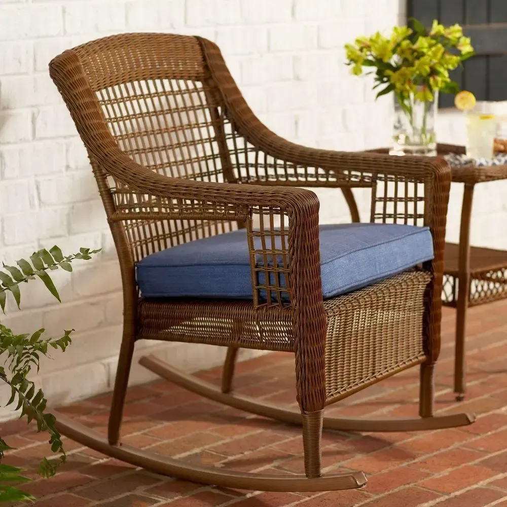 A wicker rocking chair with a blue cushion