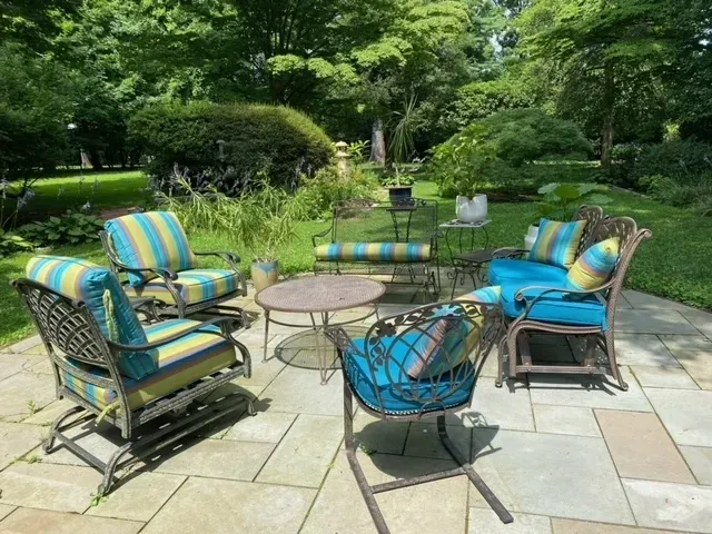 A patio with blue and yellow striped furniture and a table