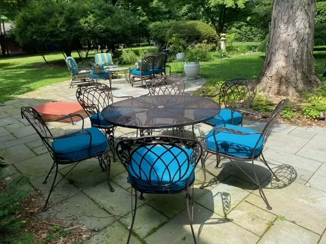 A table and chairs on a patio with blue cushions