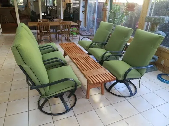 A patio set with green cushions and a wooden table