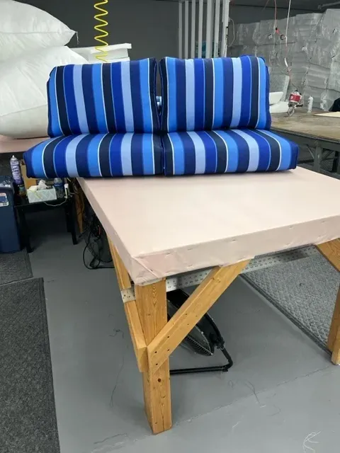 A blue striped couch is sitting on top of a wooden table