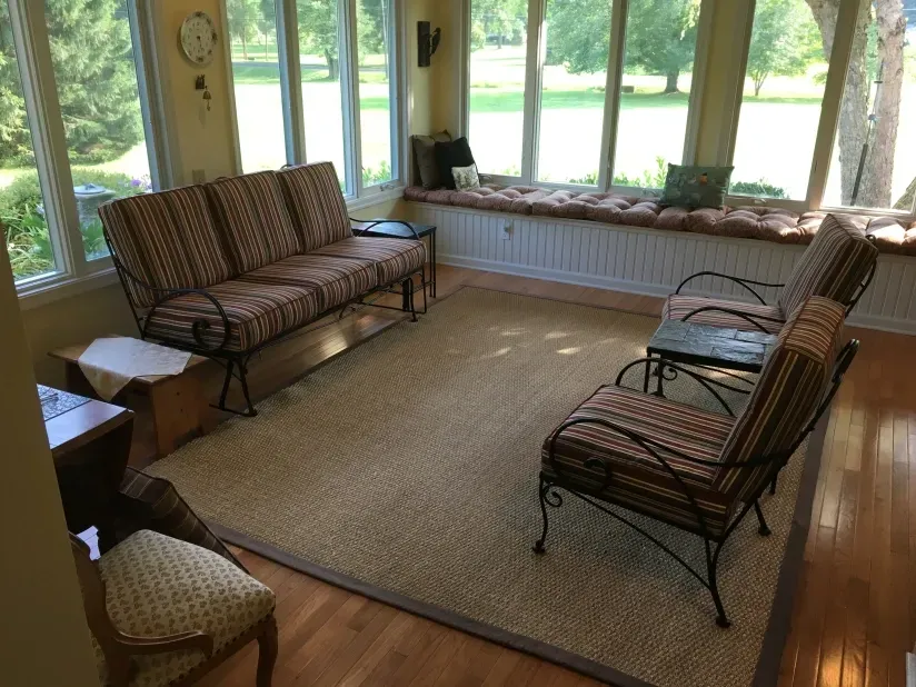 A living room with a couch and chairs and a rug