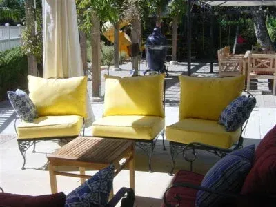 A patio with yellow chairs and a table