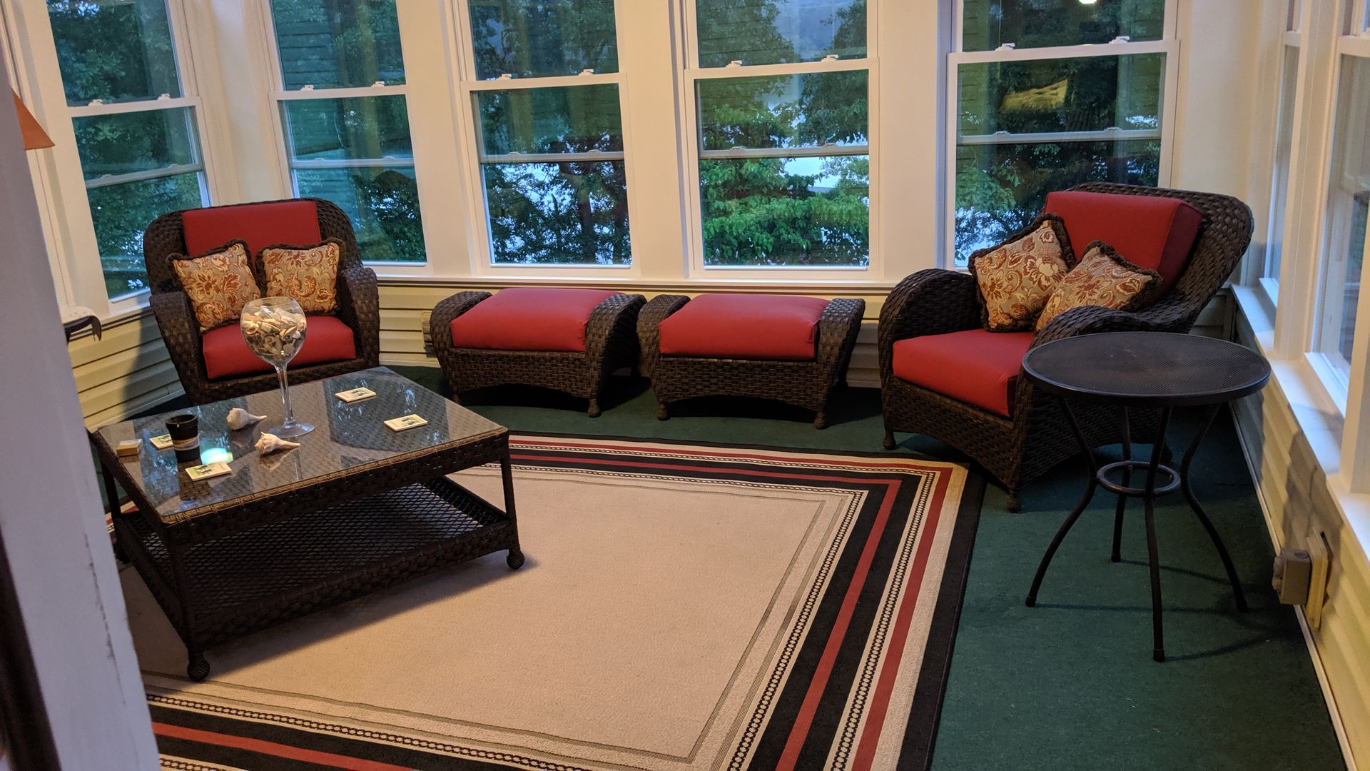 A living room with wicker furniture and a rug