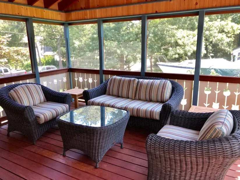 A screened in porch with wicker furniture and a couch