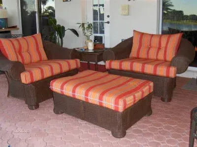 Two chairs and an ottoman on a patio with striped cushions