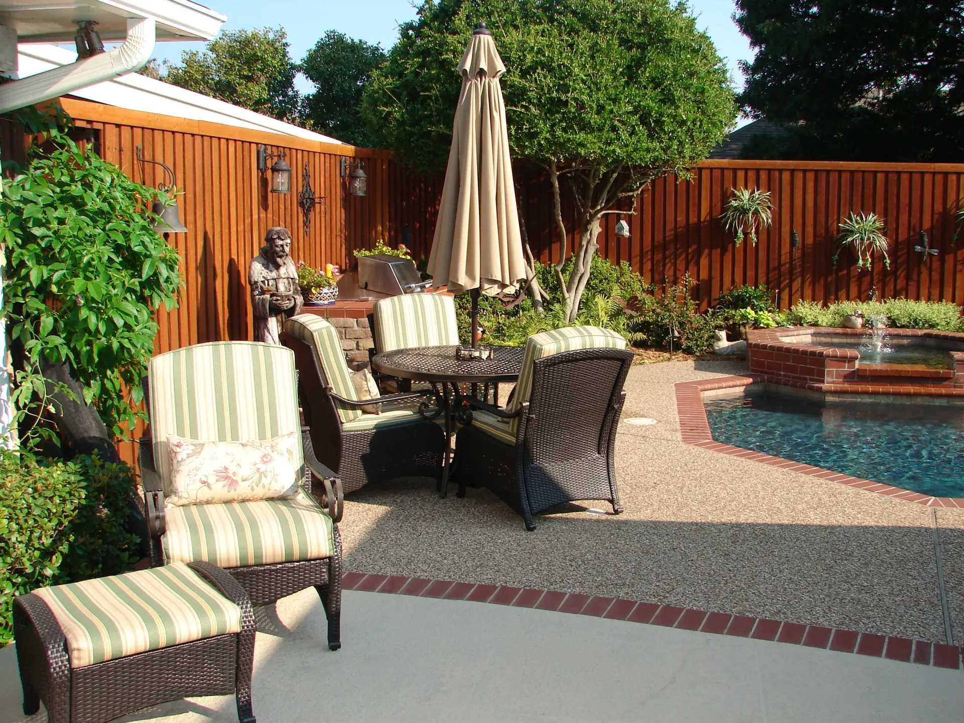 A patio with a table and chairs next to a pool