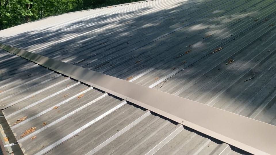 Metal roof with a diagonal seam and light reflections from sunlight
