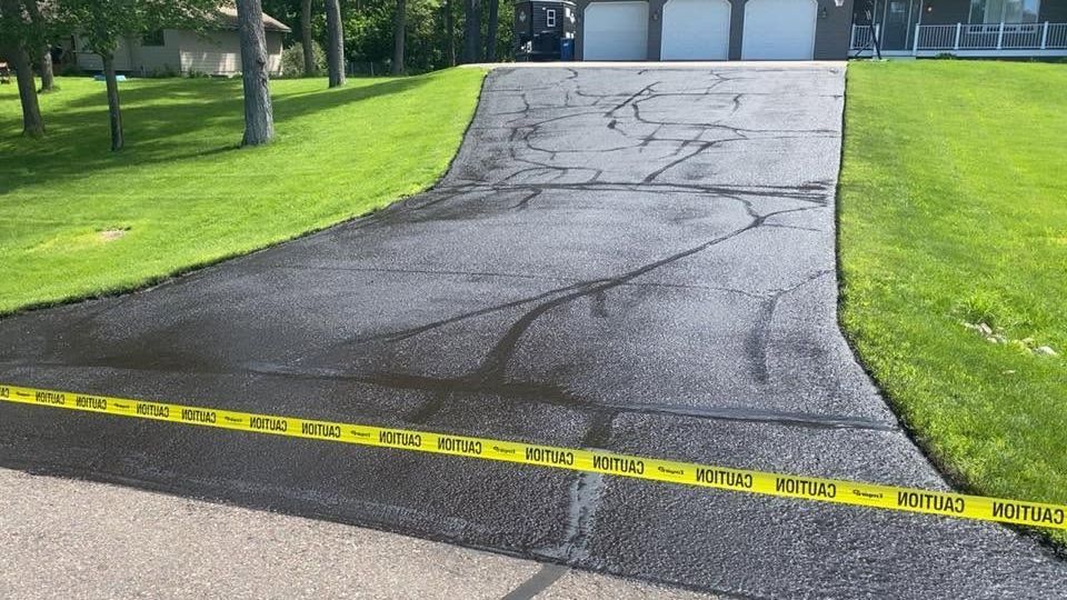 Cracked asphalt hill in a park, marked off with yellow caution tape.