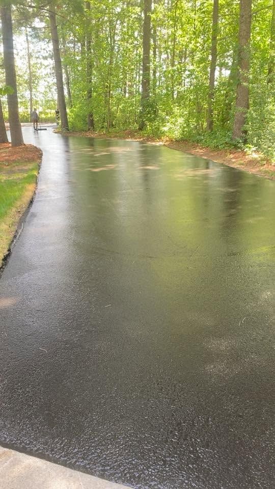Rainy wet road curving through a green wooded park