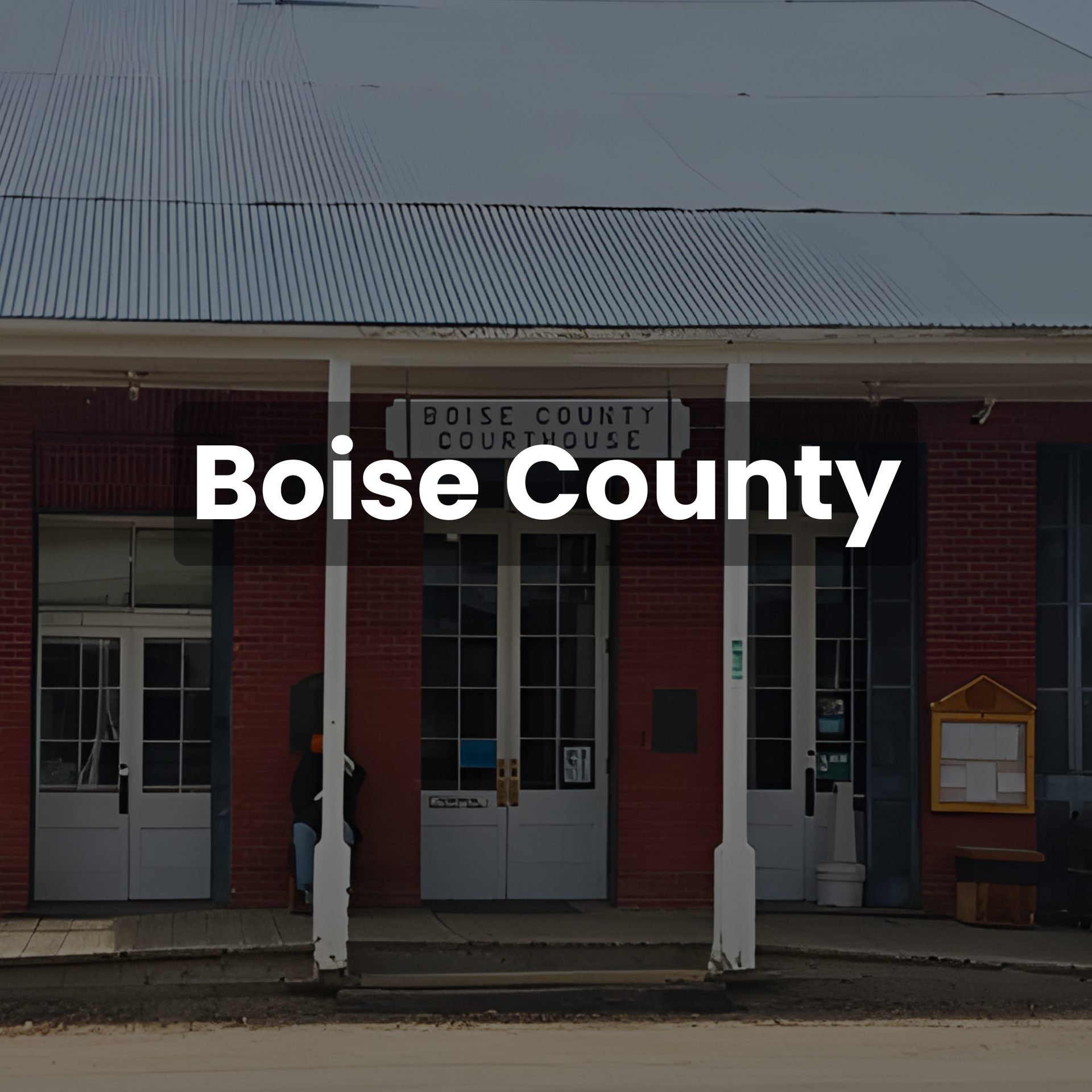 Boise County Courthouse exterior with red brick and white doors, under a gray roof.