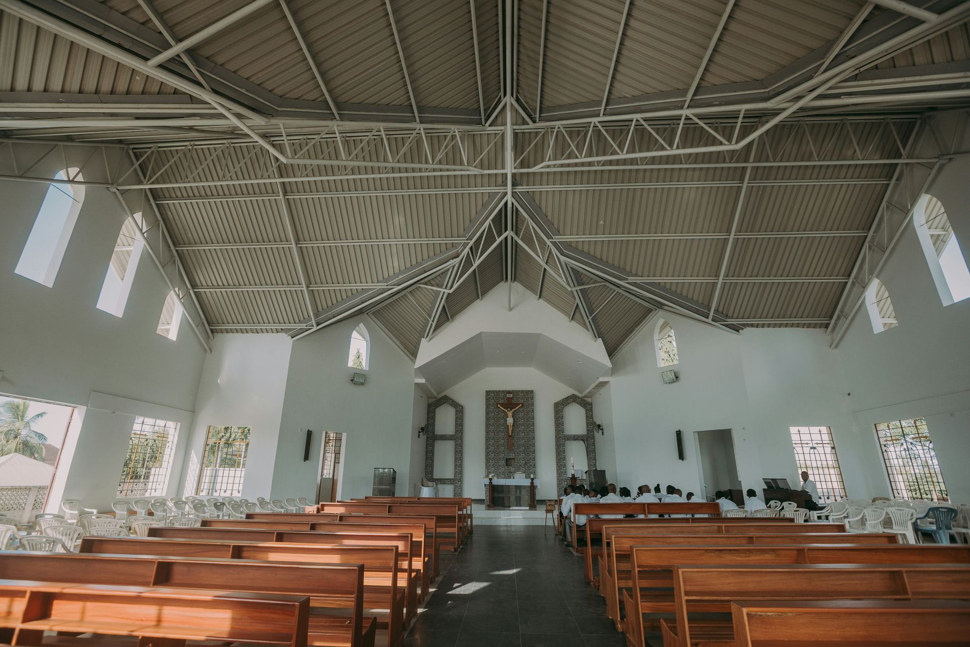 Interior of a church with wooden pews and high white ceiling.