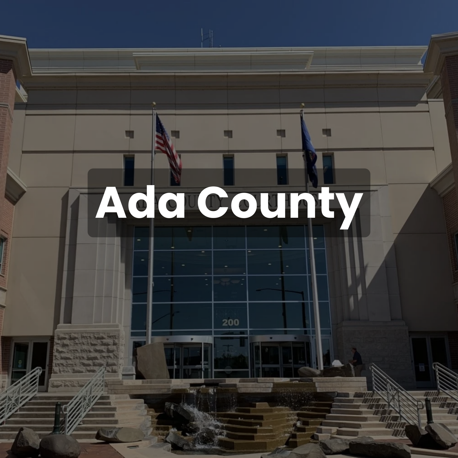 Ada County Courthouse exterior, with flags and water feature in front.