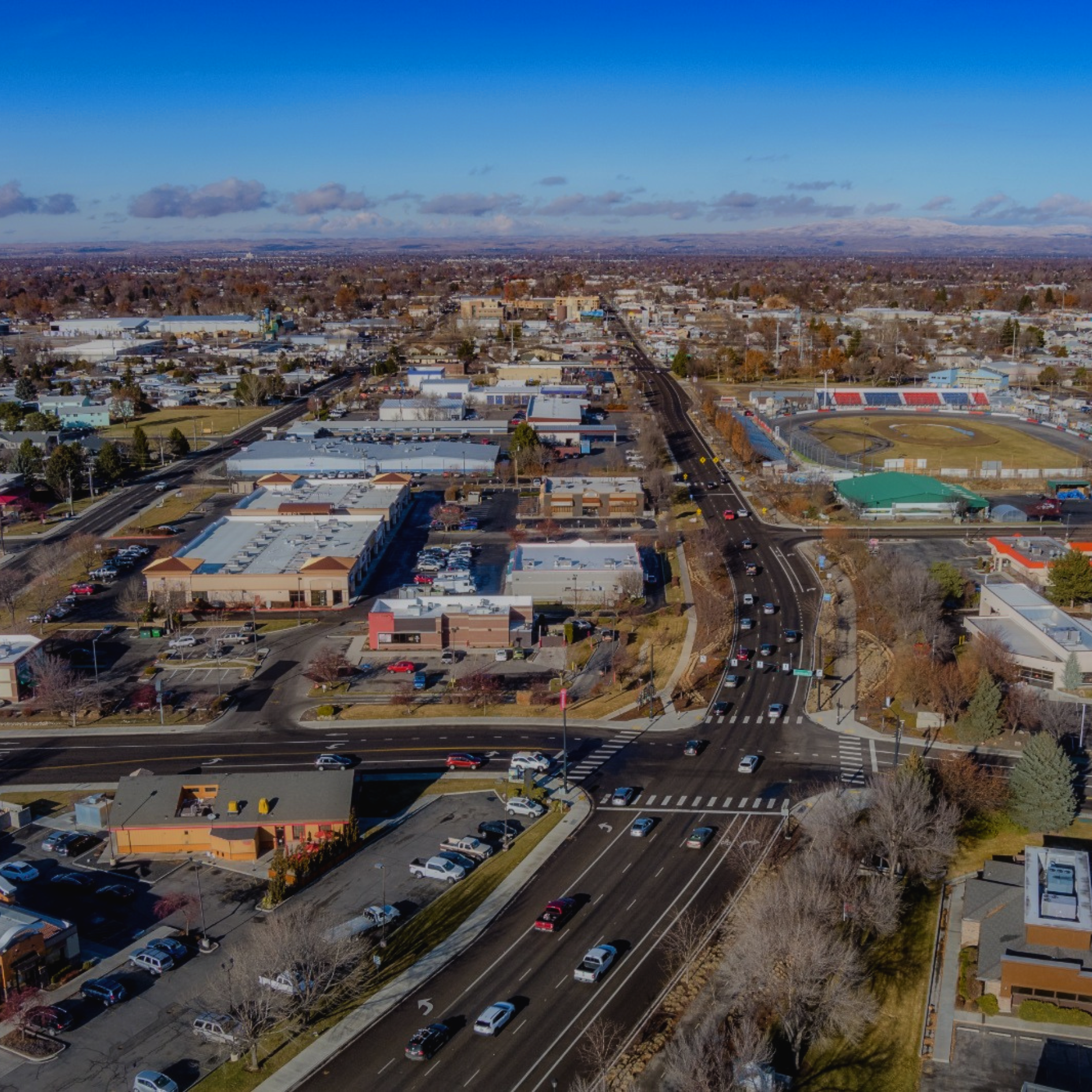 Boise Aerial view of a city street with buildings and cars, under a clear blue sky.