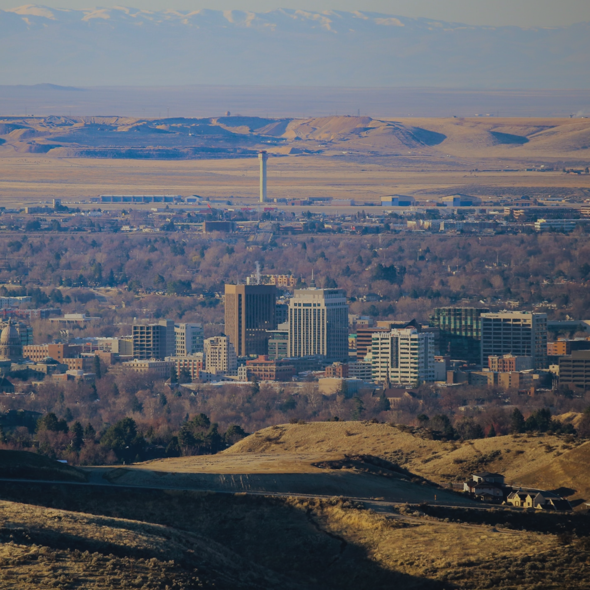 Boise Boise, Idaho cityscape with buildings and hills under a clear sky.