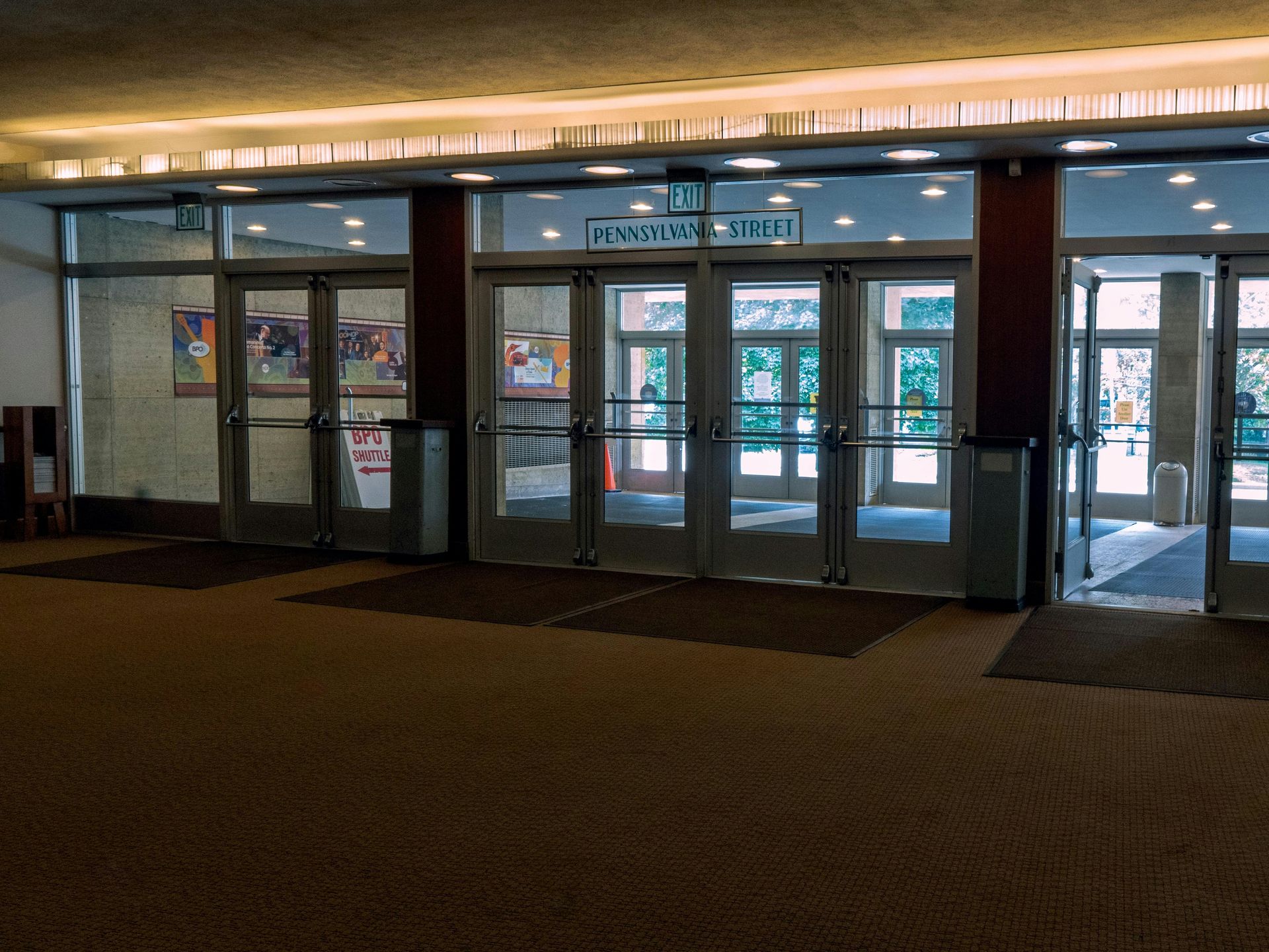 Entrance doors to a building with glass panels and a sign reading