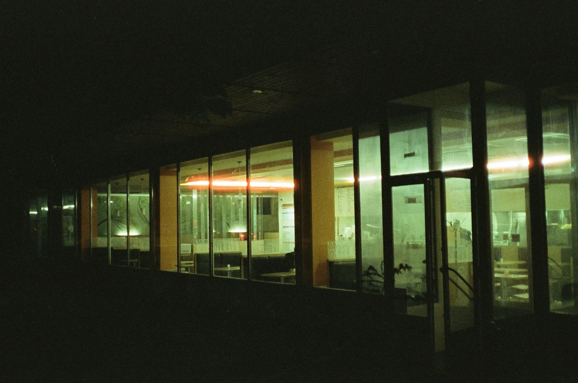 Building with large windows lit from within at night.