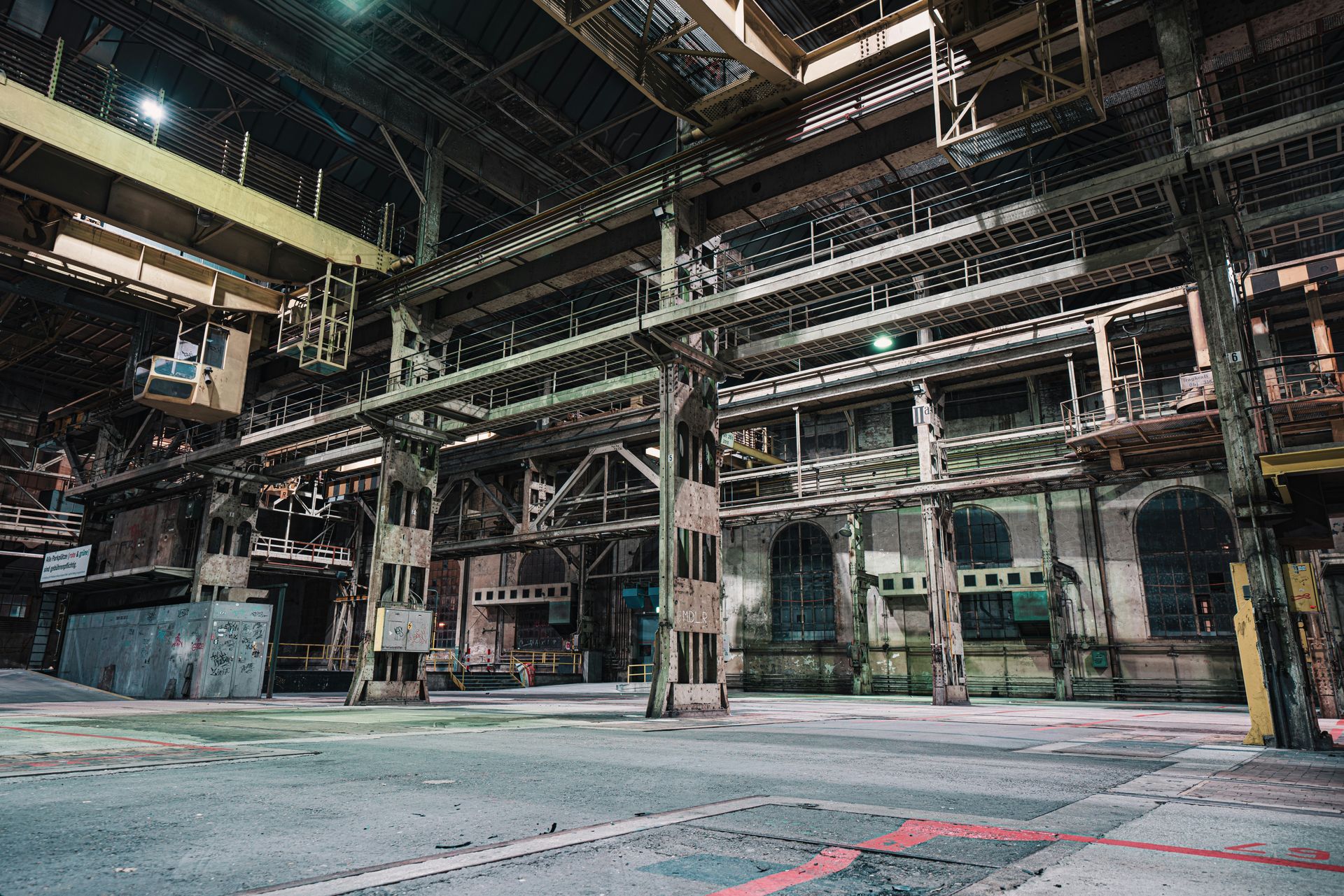 Interior view of an industrial building with metal structures, concrete floors, and multiple levels.