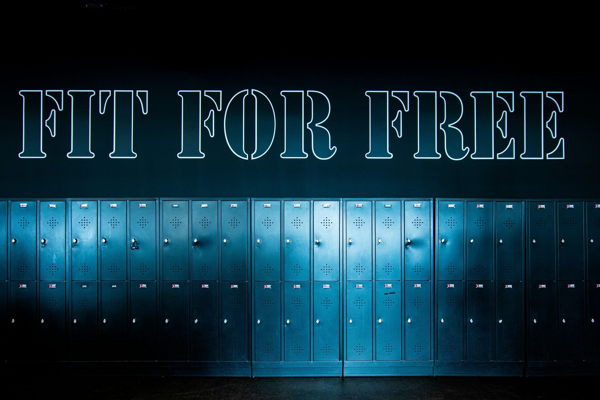 Blue lockers beneath neon sign reading