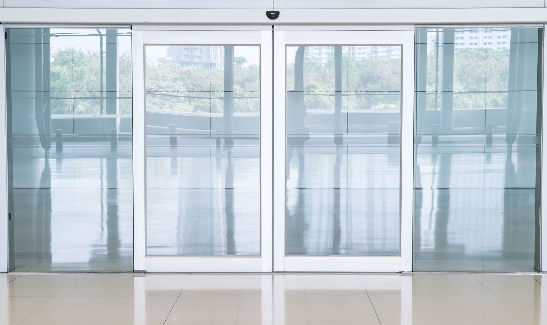 Automatic sliding glass doors with a white frame in a building.