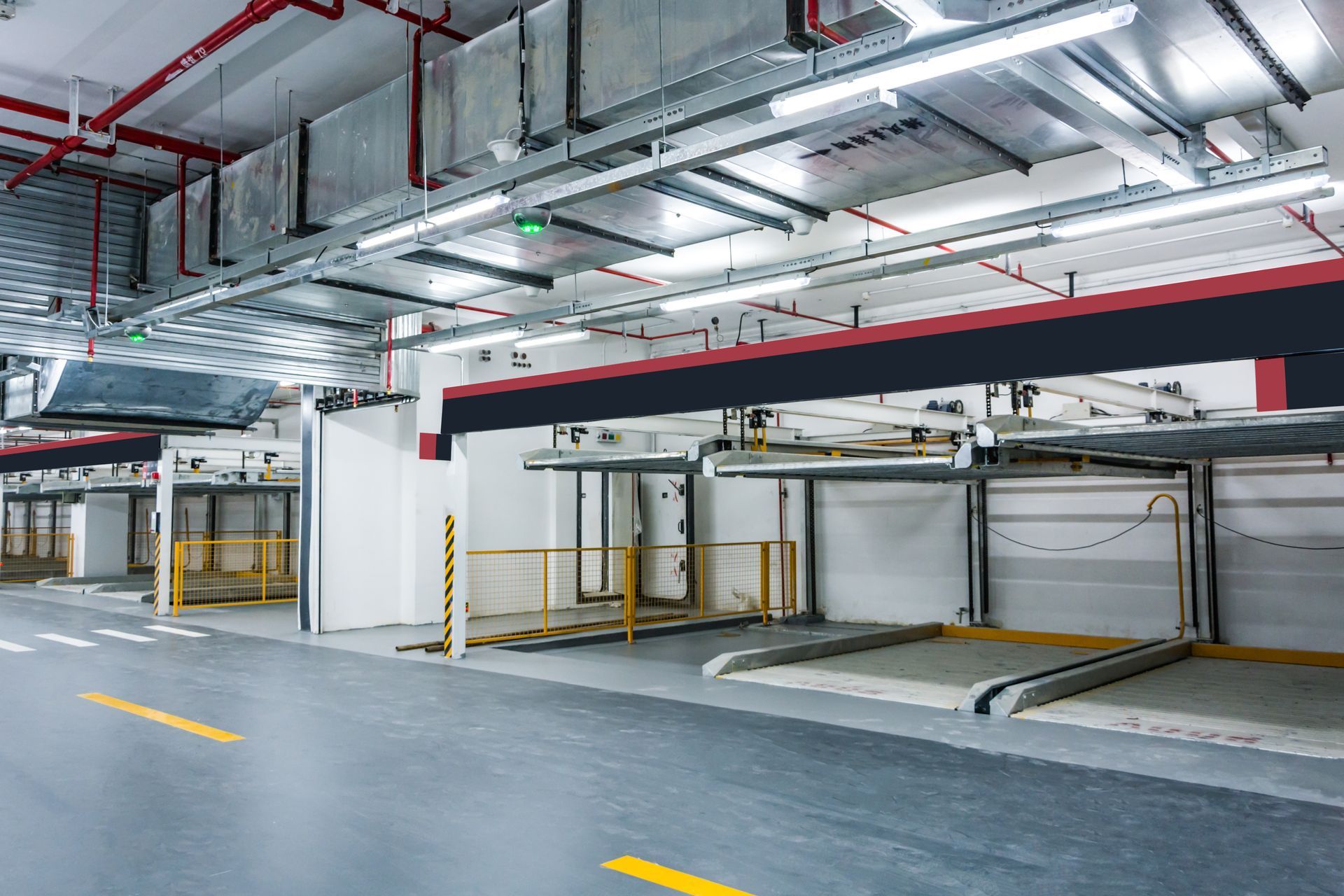 Parking garage with stacked car lifts, overhead lights, and ventilation.