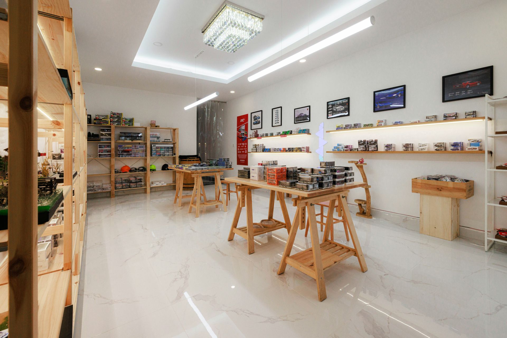 A well-lit toy store with wooden shelves and display tables filled with model cars.