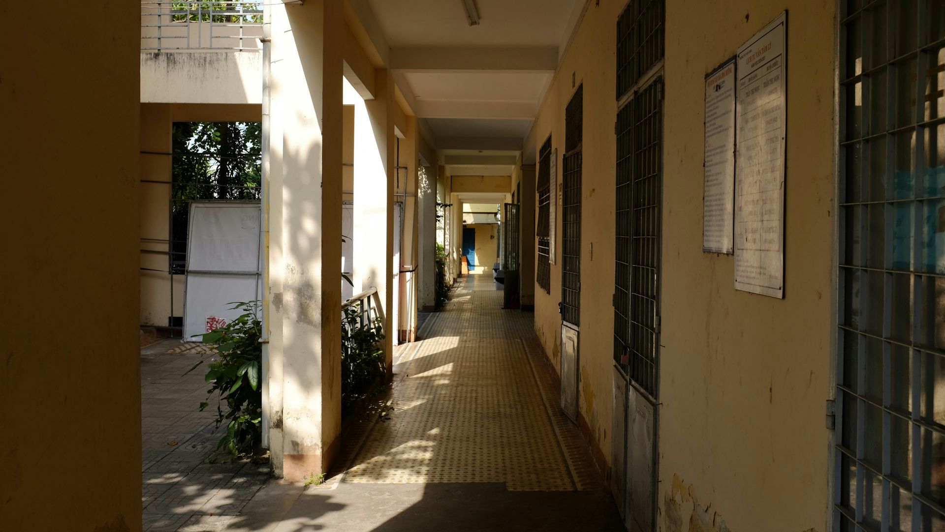 Hallway with natural light and bulletin boards, possibly a school or office.