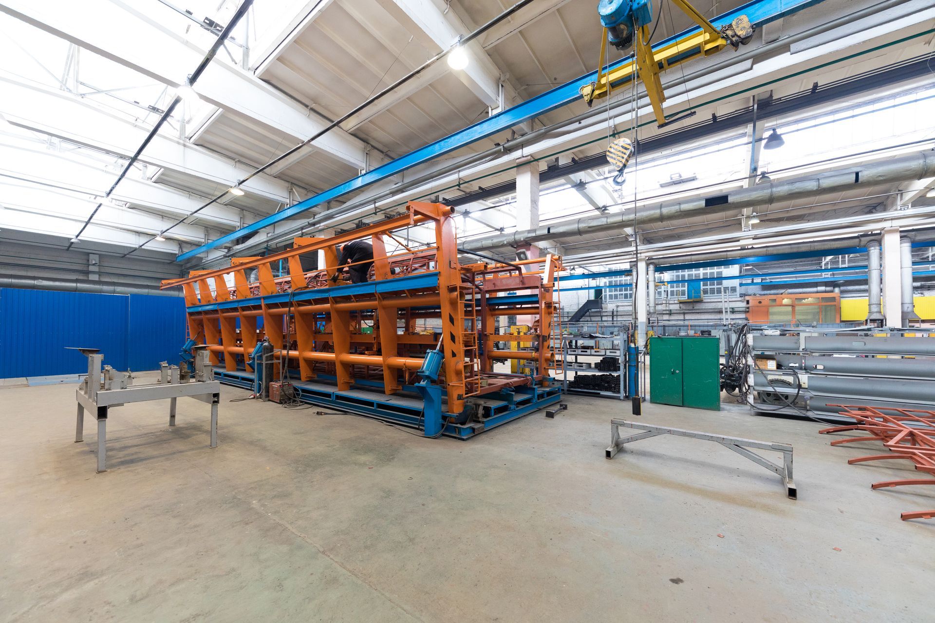 Orange and blue industrial rack in a bright warehouse with other equipment.