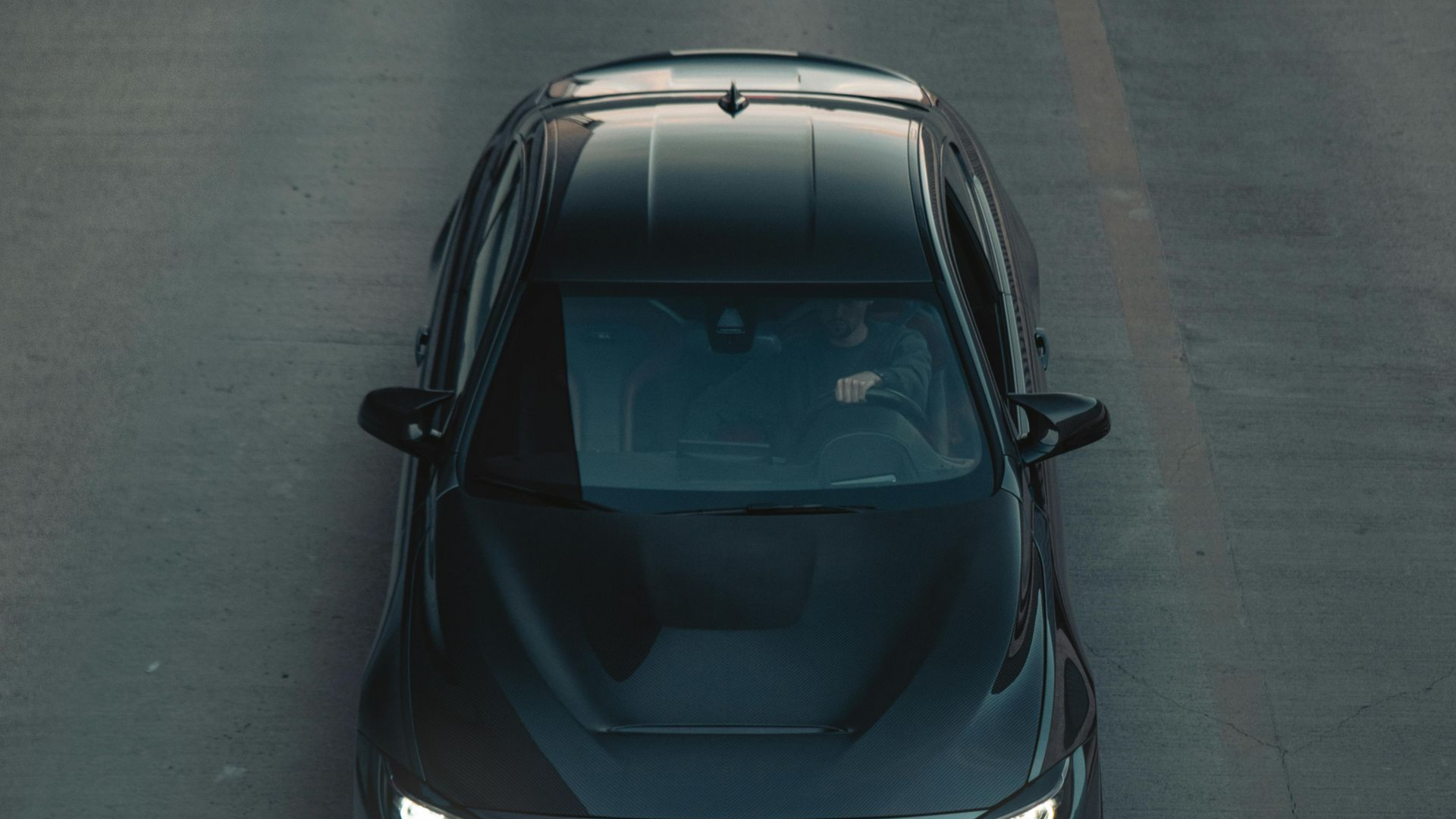 Black car driving on a road, aerial view.