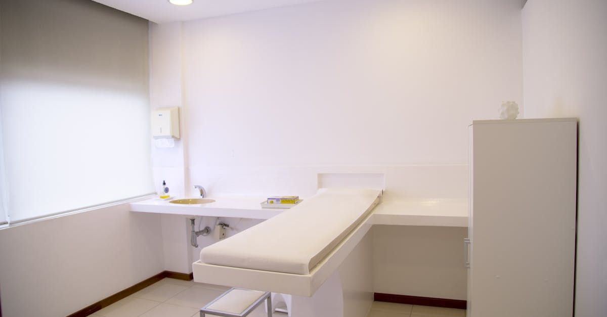 Examination room with white walls and a medical examination table.