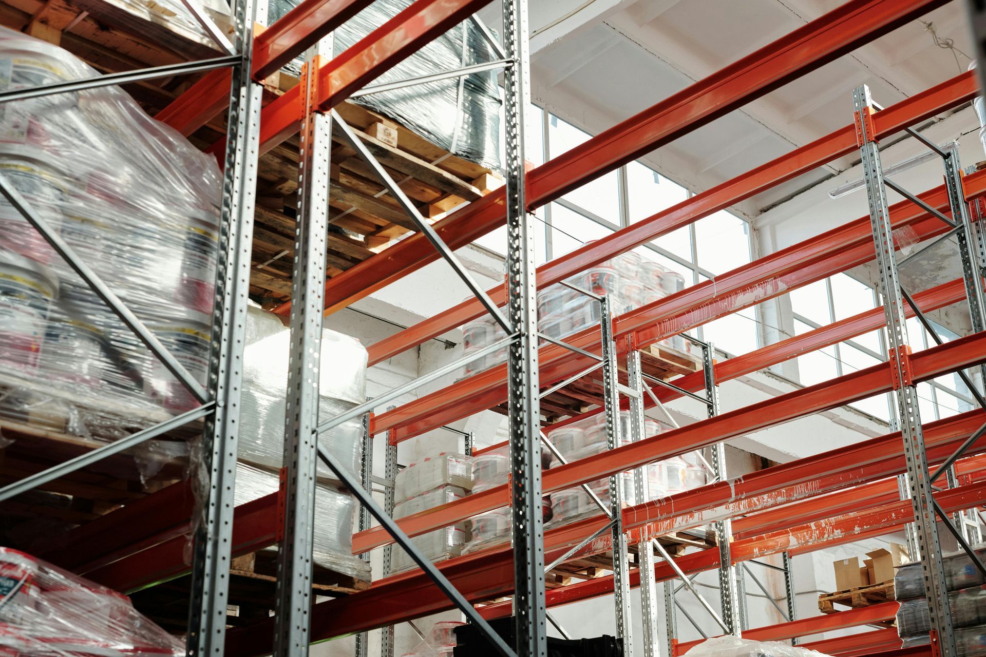Warehouse shelving filled with packaged goods, illuminated by overhead light.