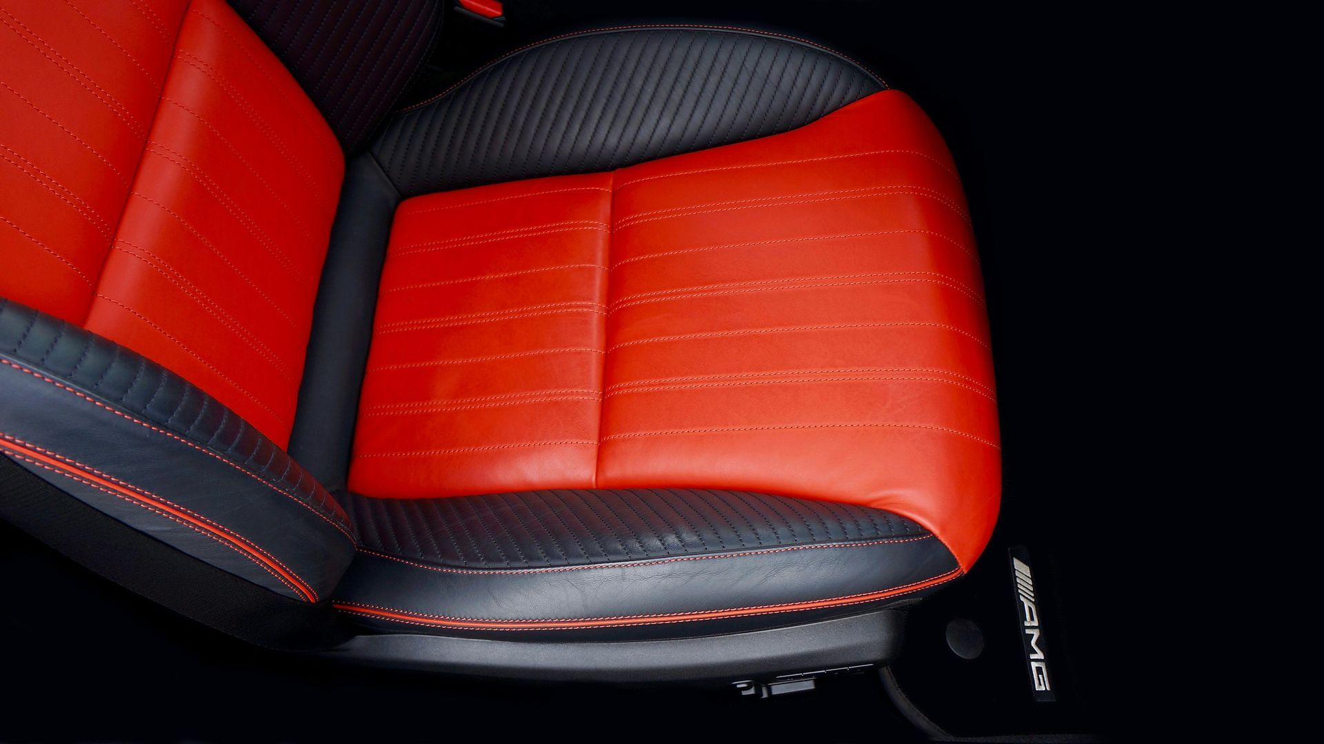 Red and black car seat with stitching detail, angled shot, interior.