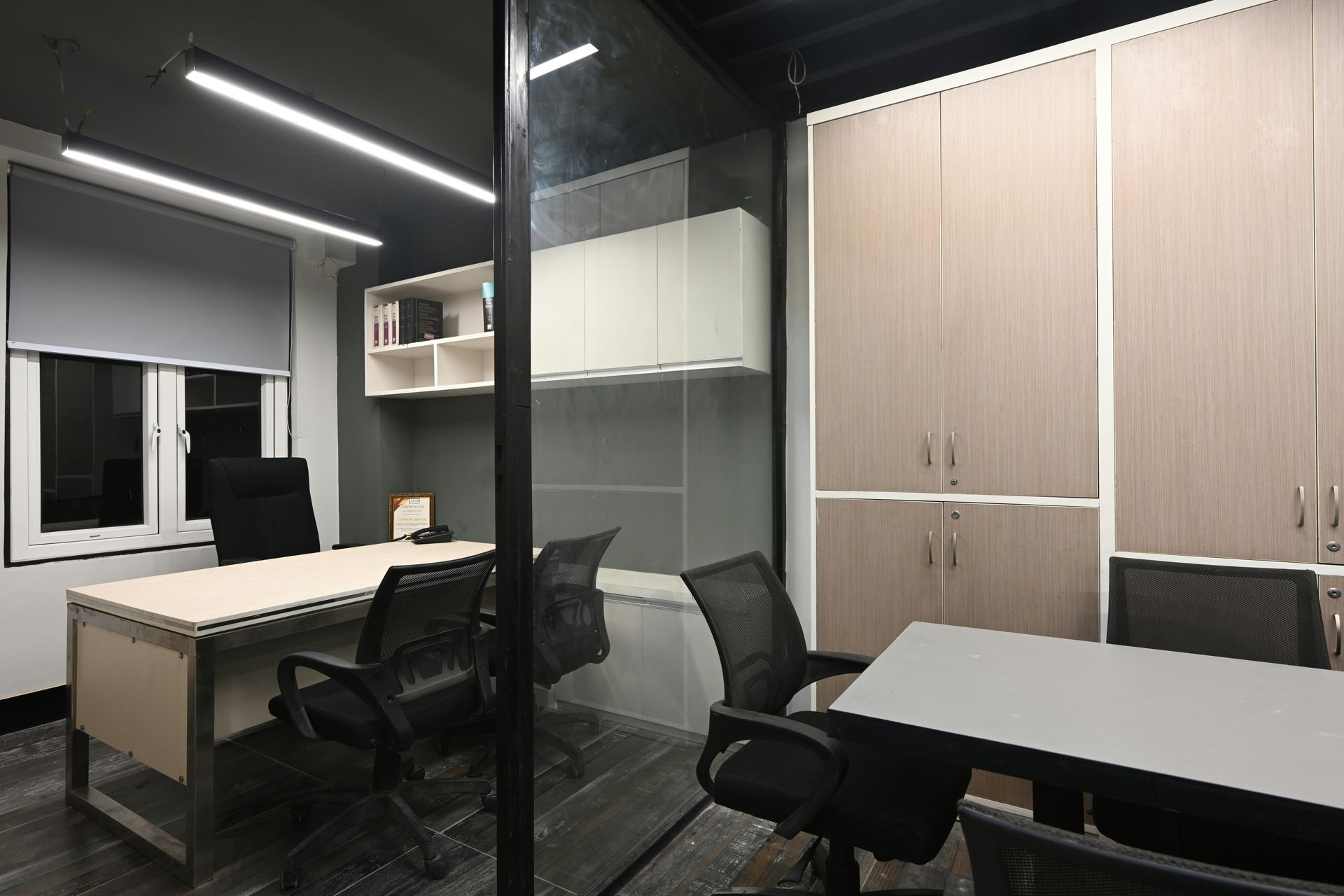 Office space with desks, chairs, storage cabinets, and a window.