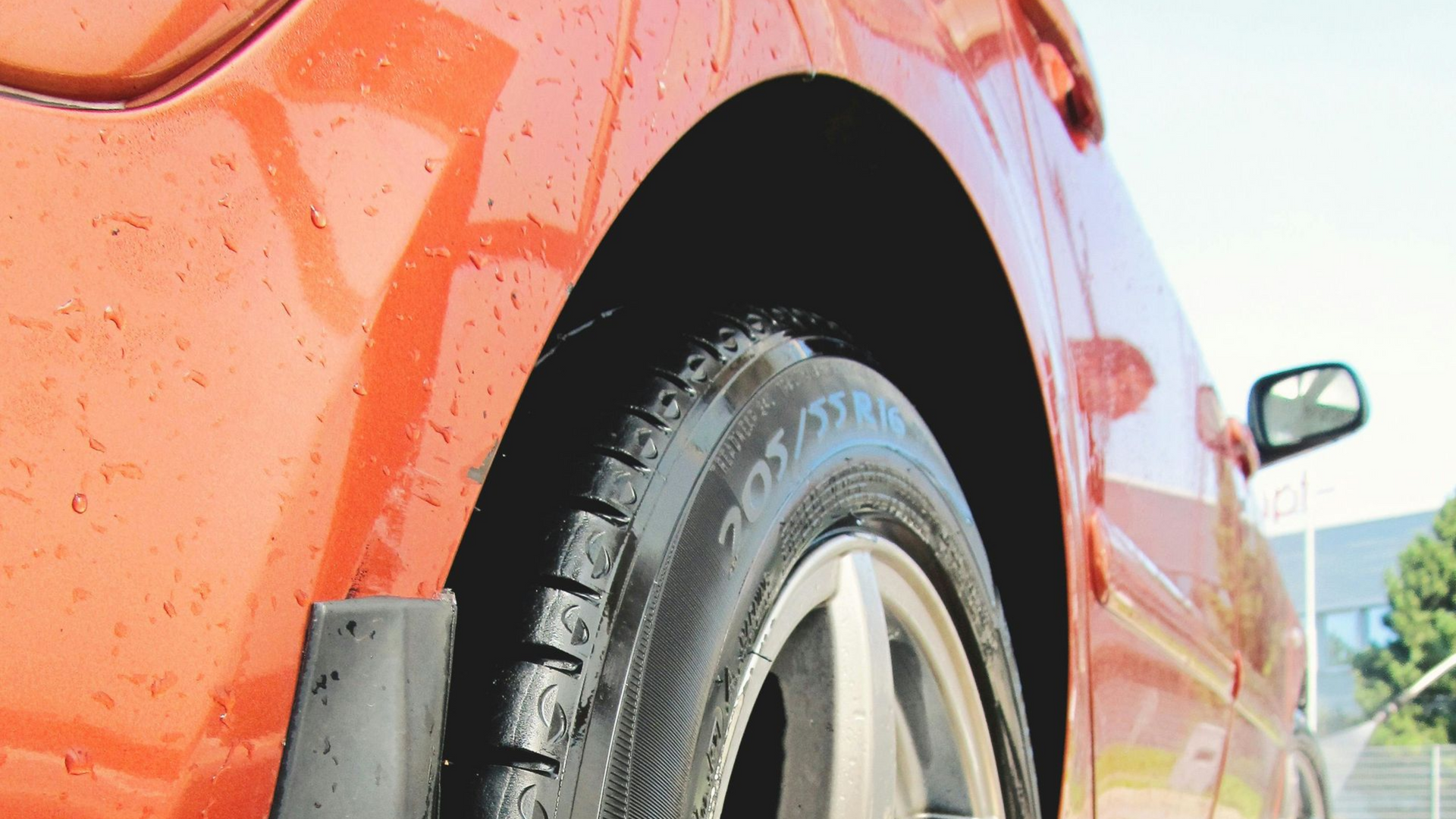 Orange car wheel close-up with a wet tire.