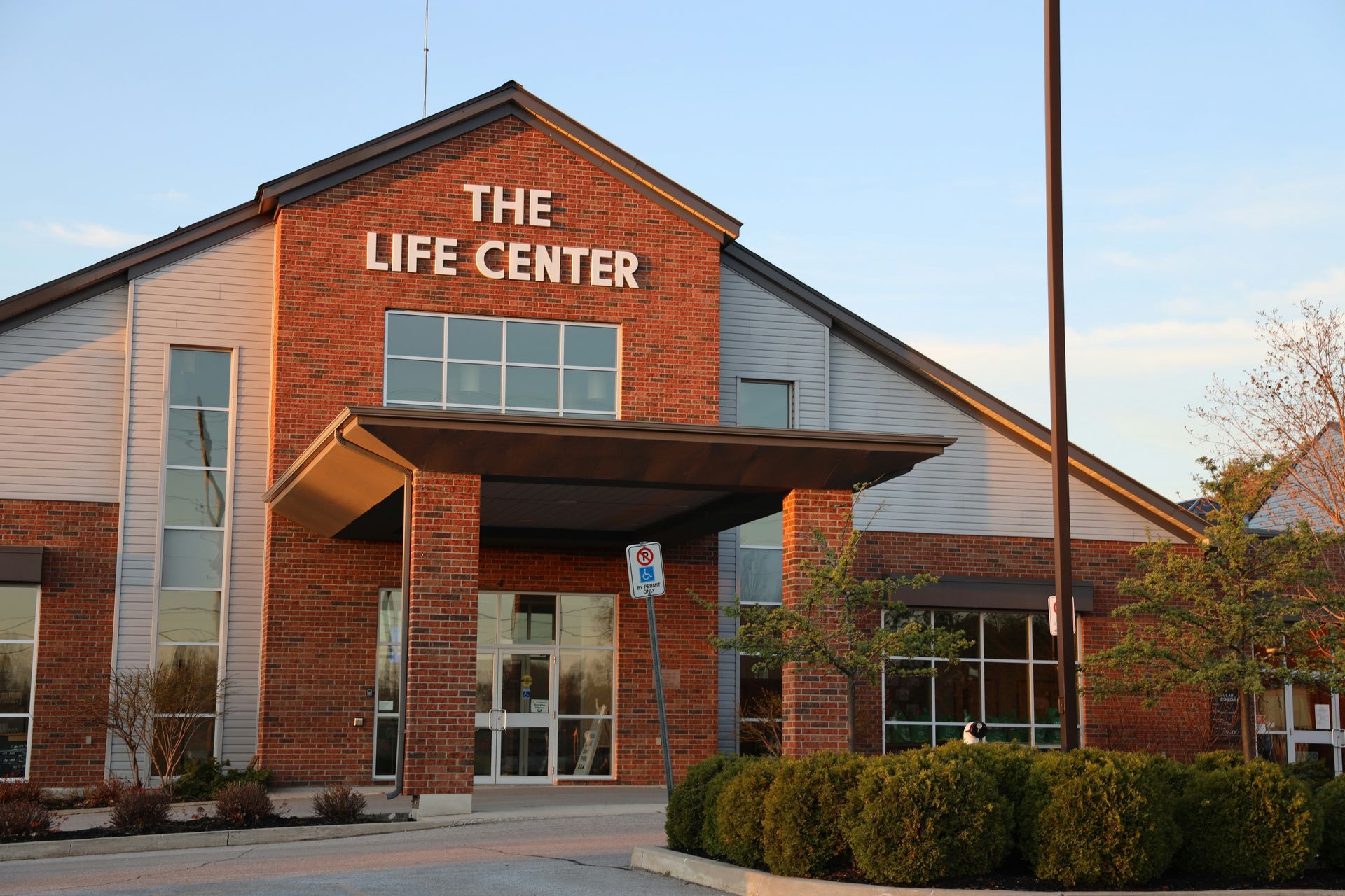 The Life Center building with brick facade and entrance canopy, white text 