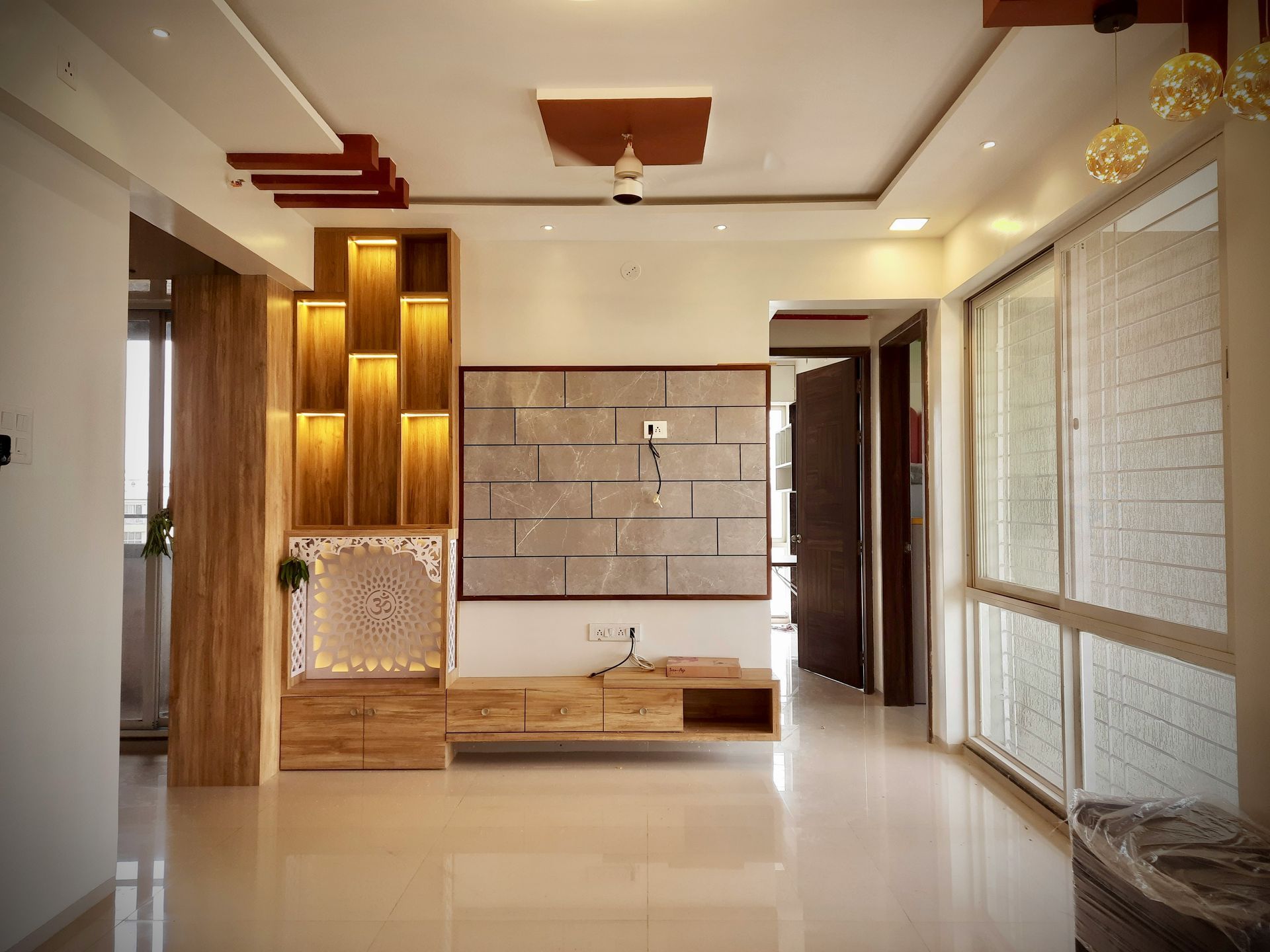 Wooden shelving unit with warm lighting and TV against a neutral wall in a modern living room.