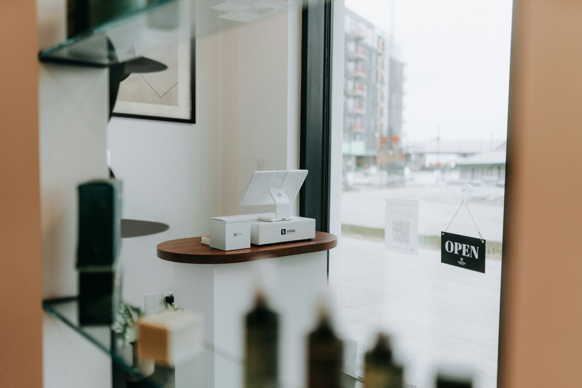 A shop interior with a point-of-sale system on a counter near a window with an