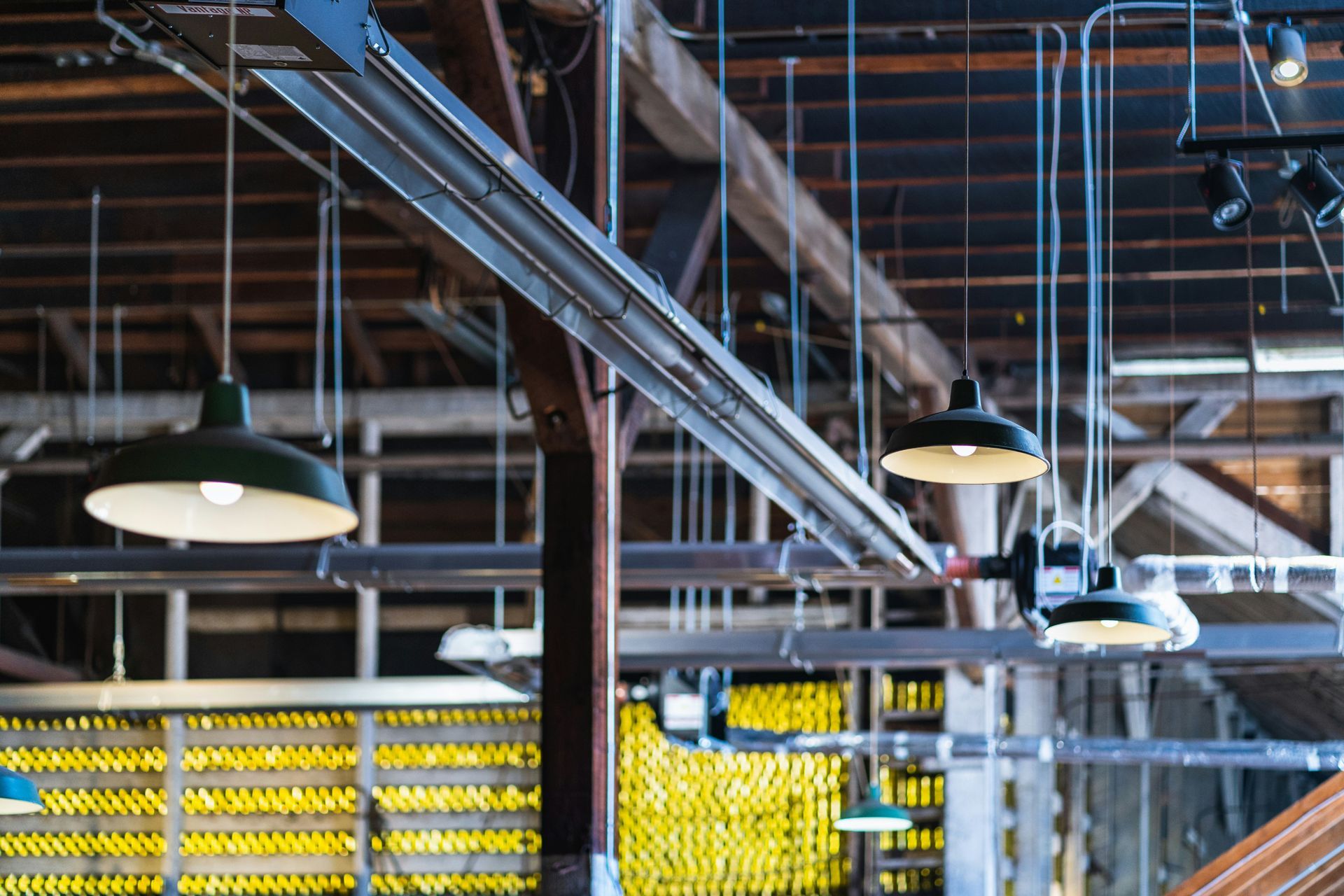 Industrial interior with hanging green pendant lights and exposed beams.