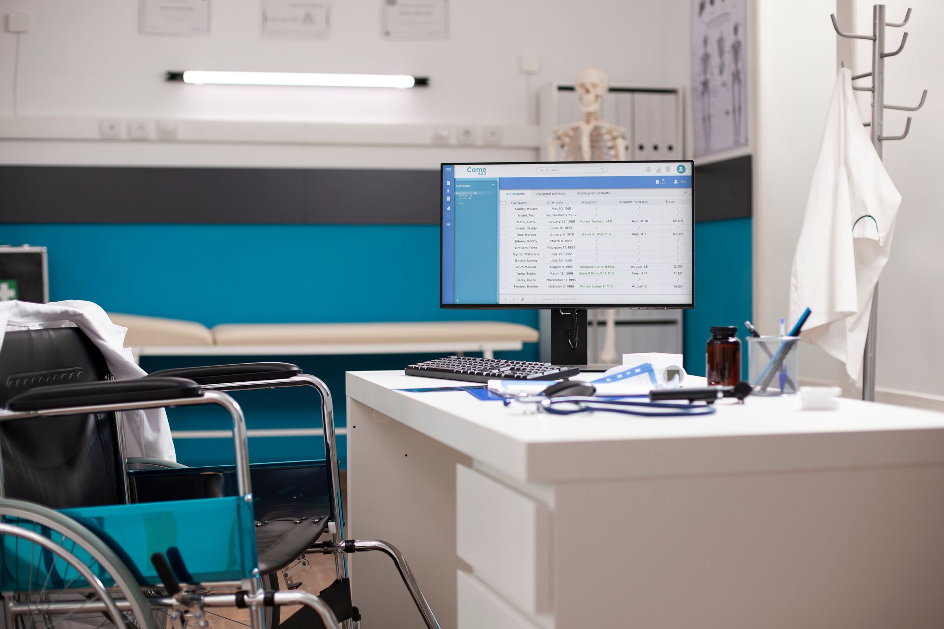 Doctor's office interior with a wheelchair, desk, computer, examination bed, and medical supplies.