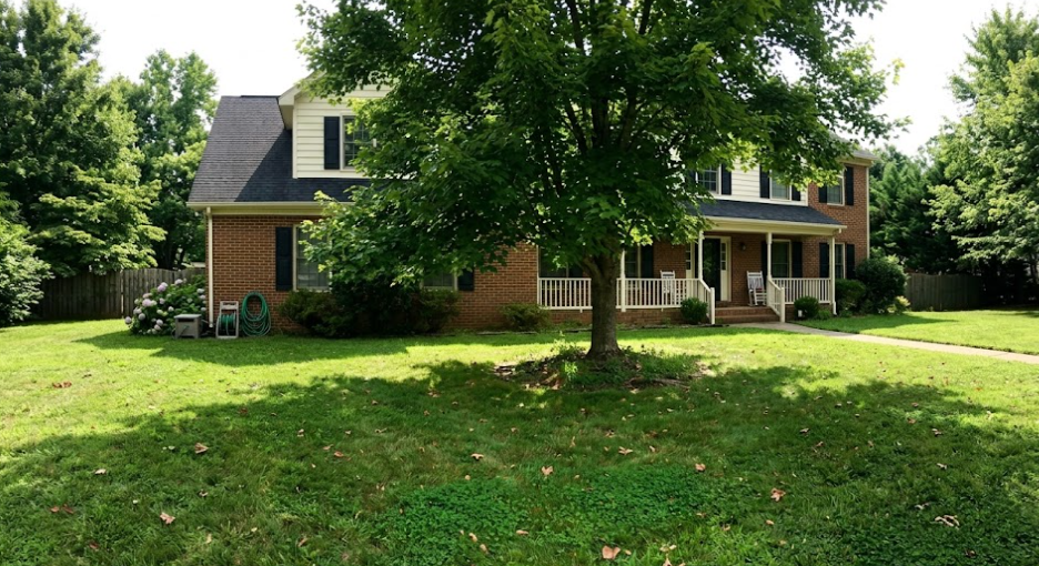 A beautifully landscaped front yard in Virginia featuring a healthy, perfectly pruned shade tree.