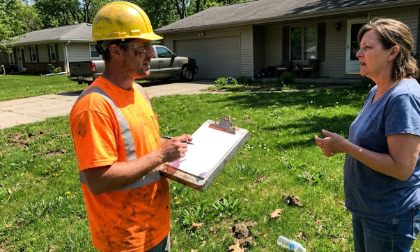A tree service professional giving a homeowner a free tree removal estimate in Charlottesville VA.