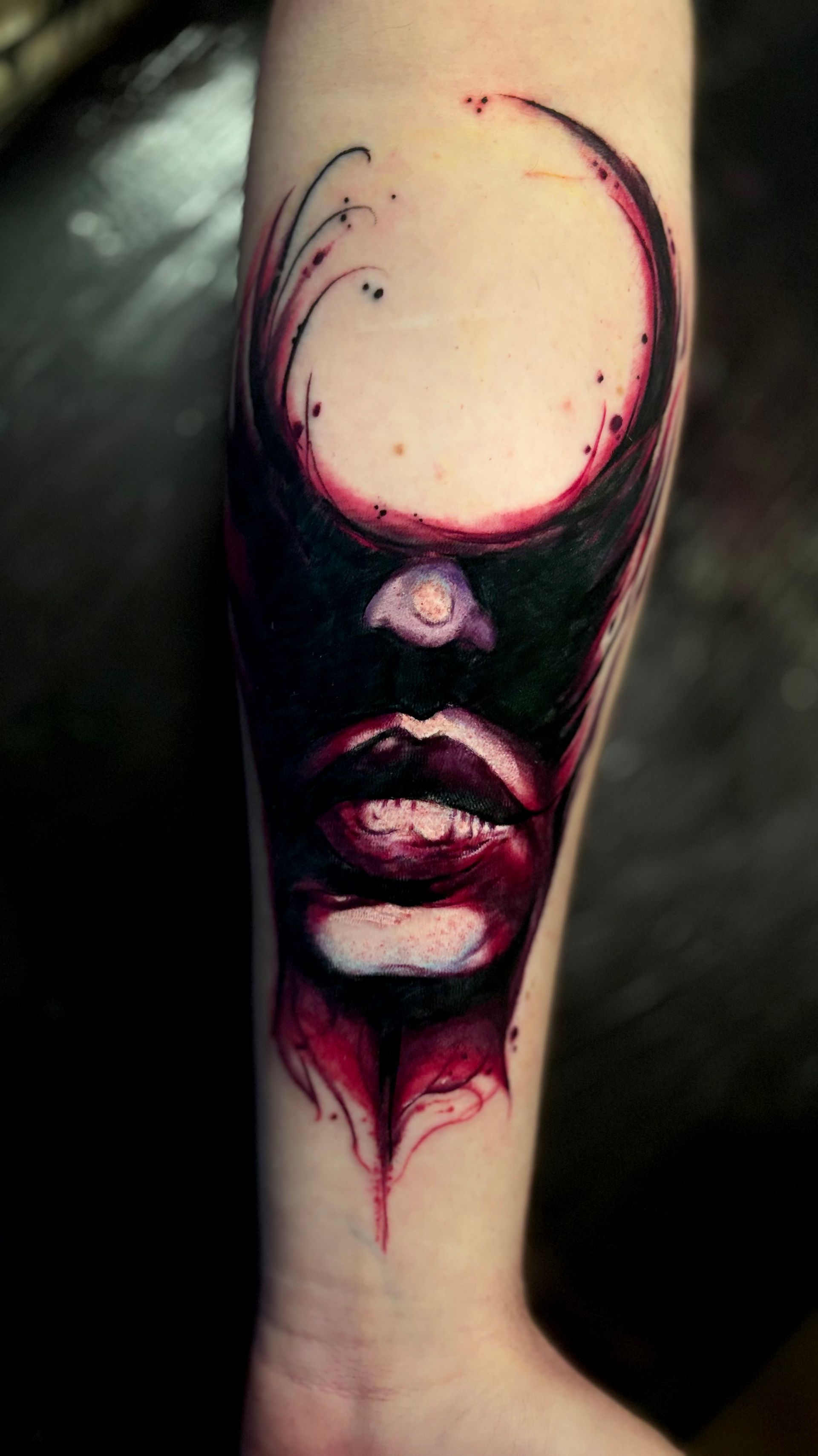 Tattoo of a face on an arm. Dark colors with red accents. Partial face silhouette with full lips.
