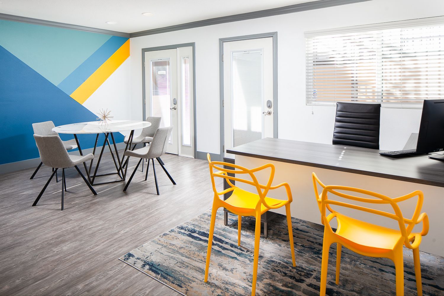 A room with a desk , chairs and a table.