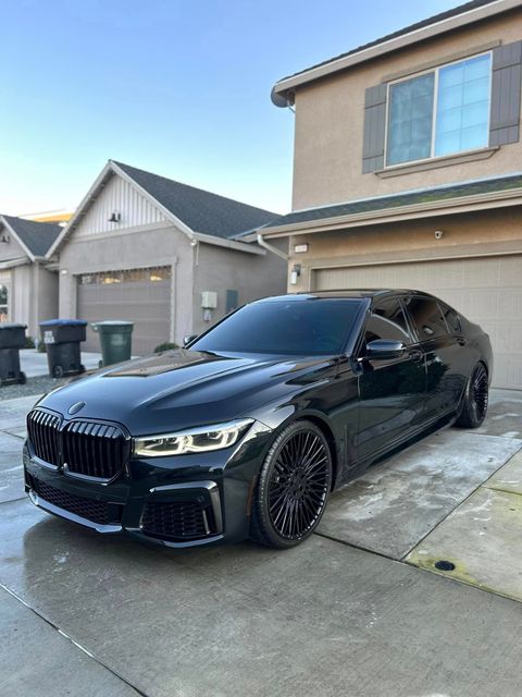 A black bmw is parked in front of a house.