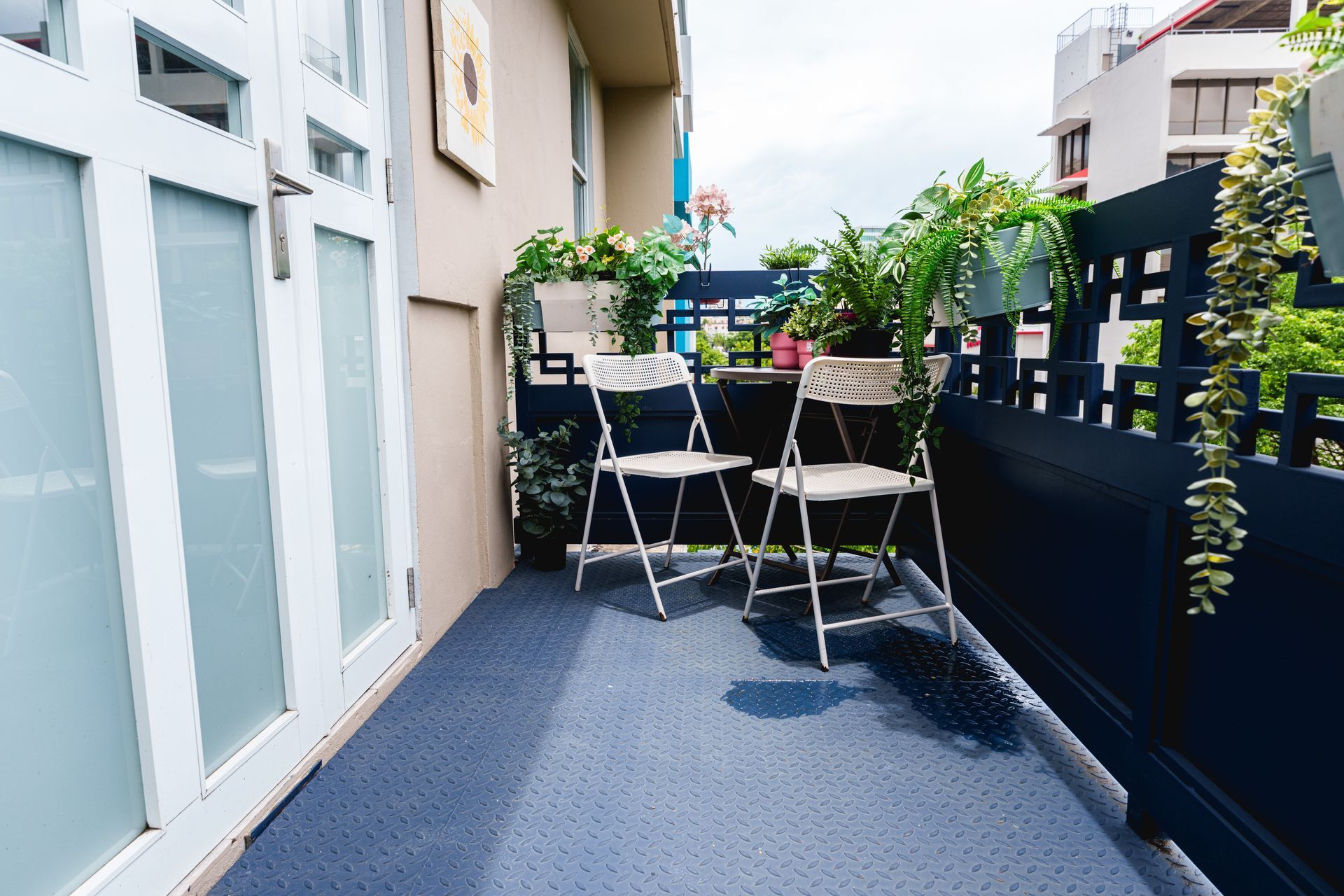 A balcony with two folding chairs and potted plants. Somos Hotel San Juan, Puerto Rico Avenida Ponce de Leon