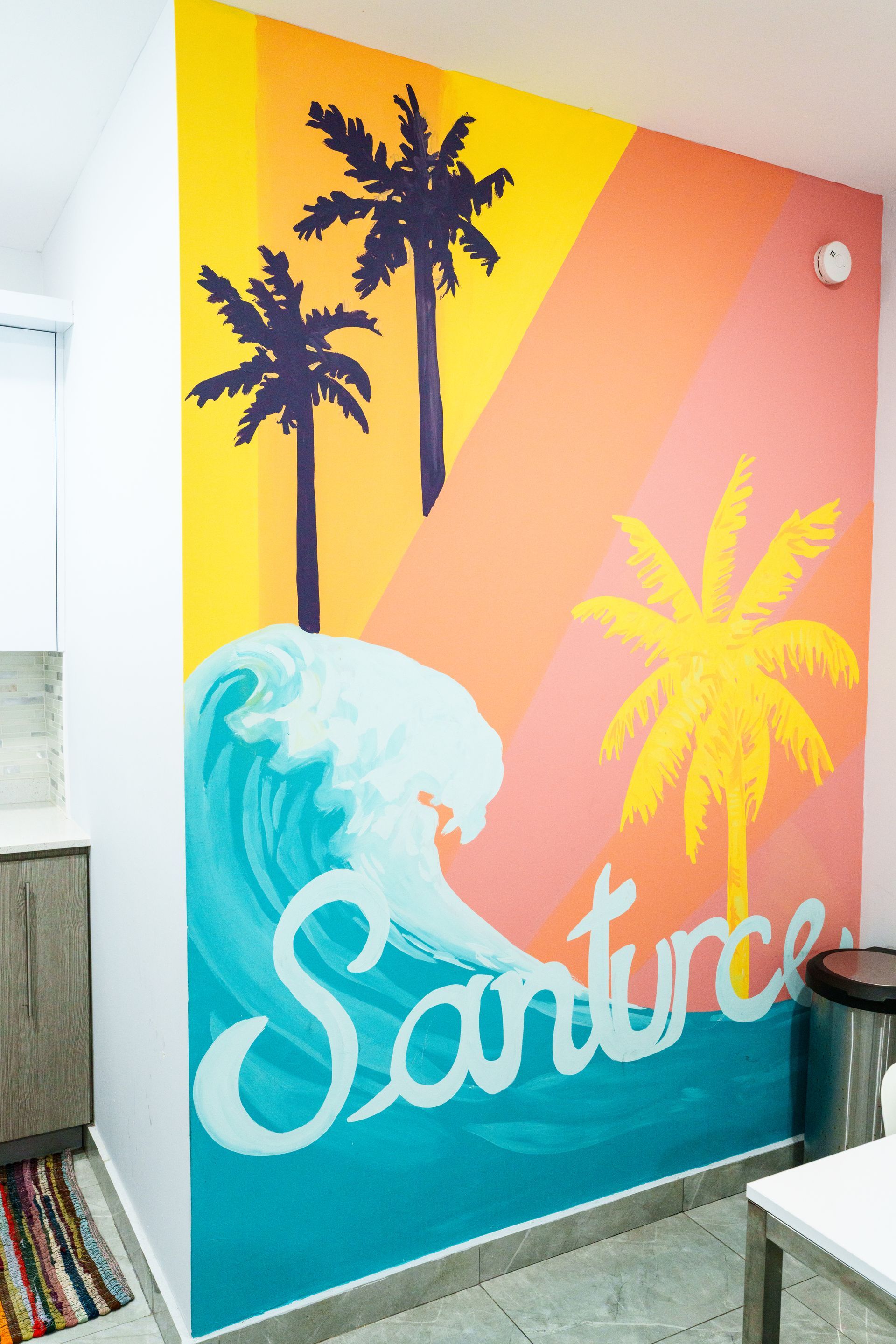 A colorful mural on a wall with palm trees and waves Somos Hotel San Juan, Puerto Rico Avenida Ponce de Leon