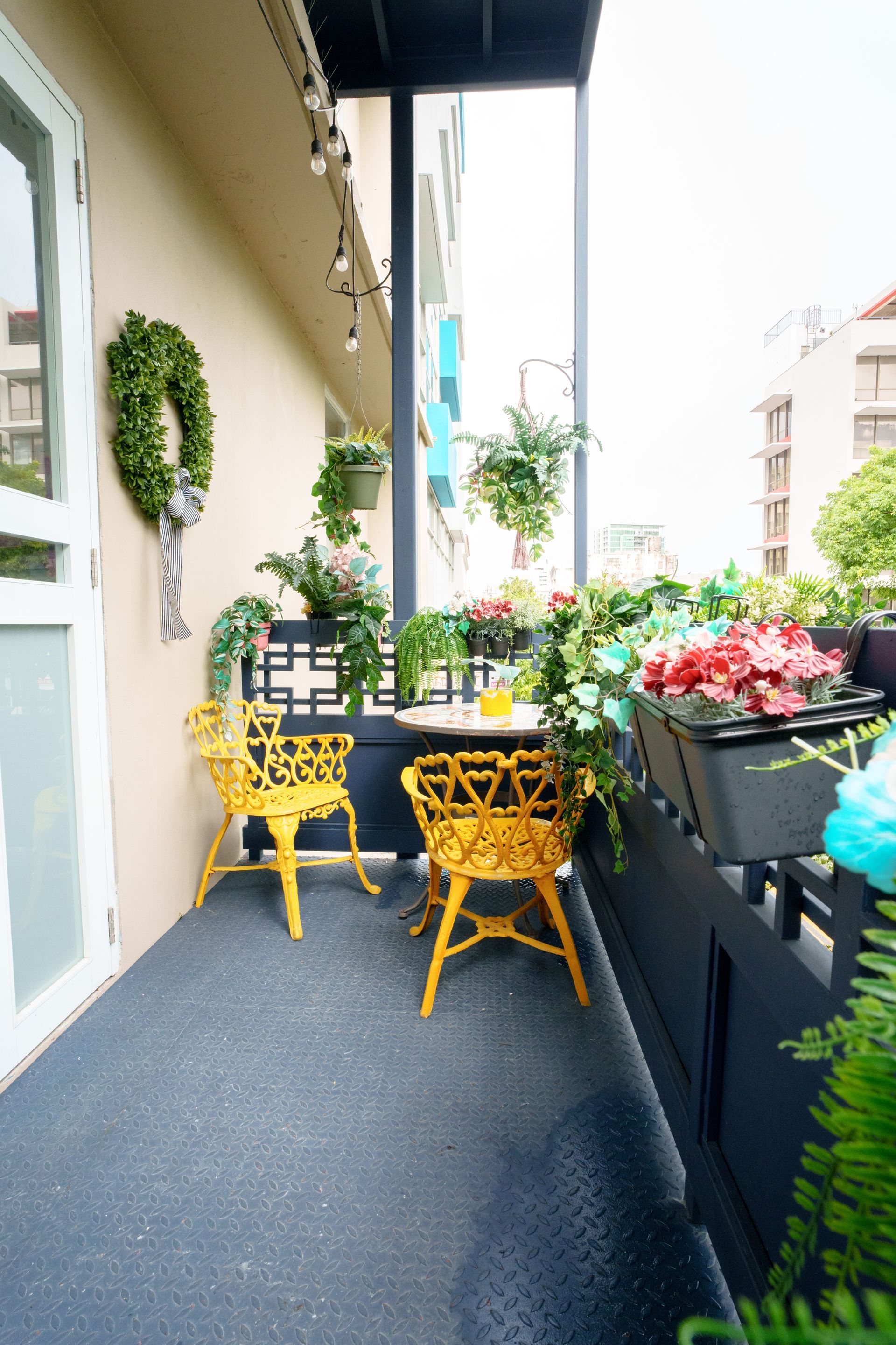 A balcony with yellow chairs and a table with flowers on it Somos Hotel San Juan, Puerto Rico Avenida Ponce de Leon