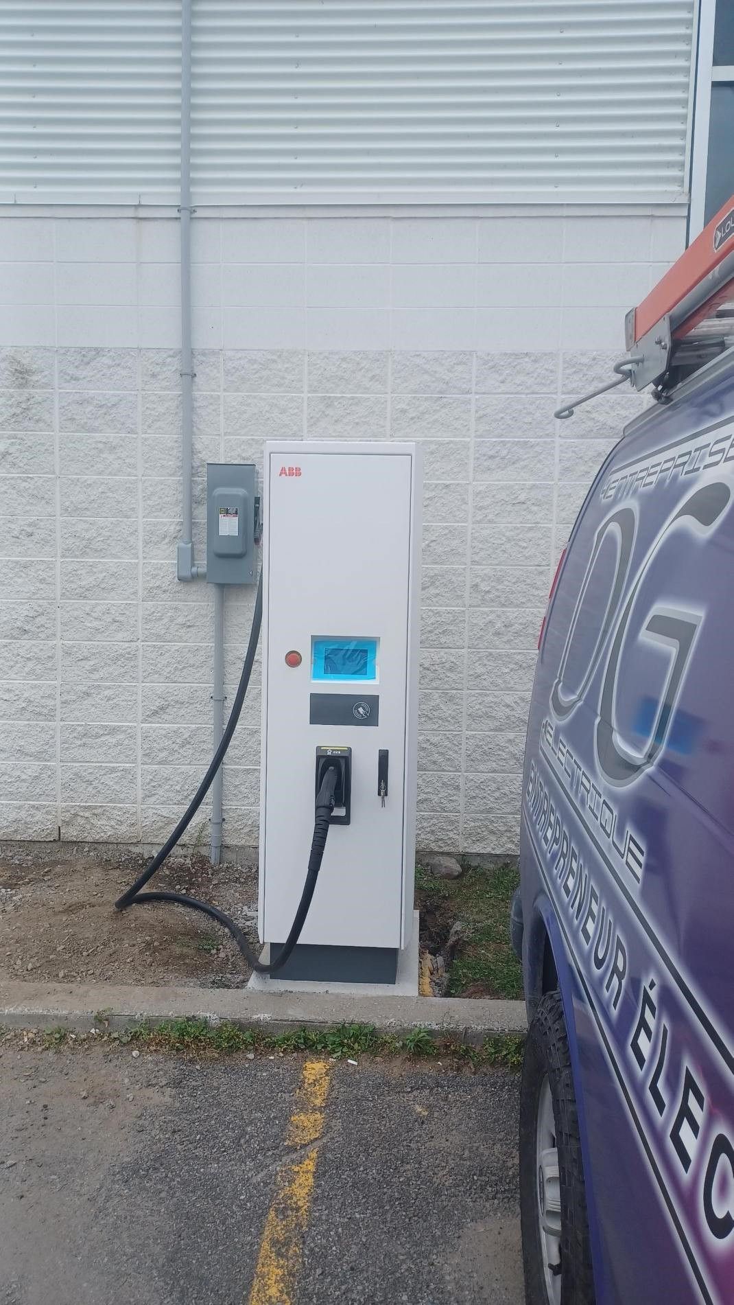 Une voiture est en train d'être rechargée sur une borne de recharge dans un parking.