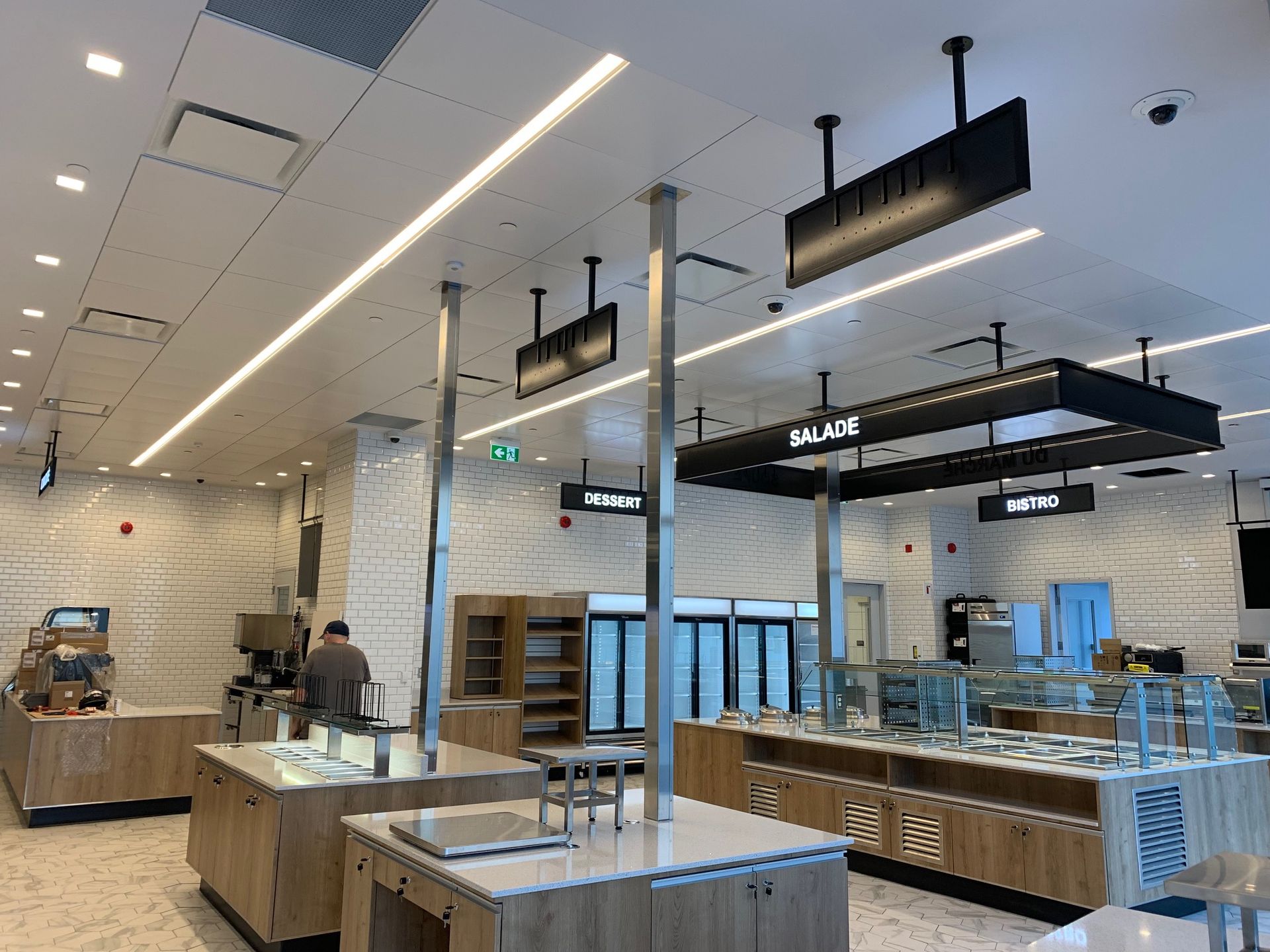 L'intérieur d'un restaurant avec beaucoup de comptoirs et d'enseignes suspendus au plafond.