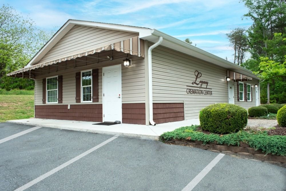Small beige commercial building with a white door, brown trim, and parking spaces outside